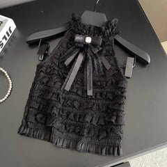 Black lace dress with a bow on a hanger on a dark surface
