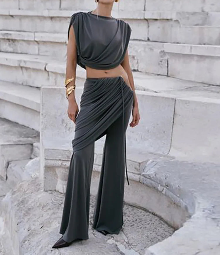 Woman in a gray outfit standing on stone steps with 'WeirdPass' branding.