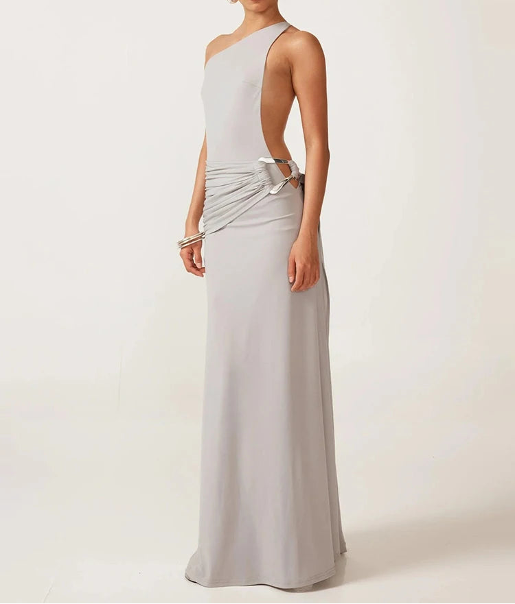 Woman wearing a silver one-shoulder gown against a white background