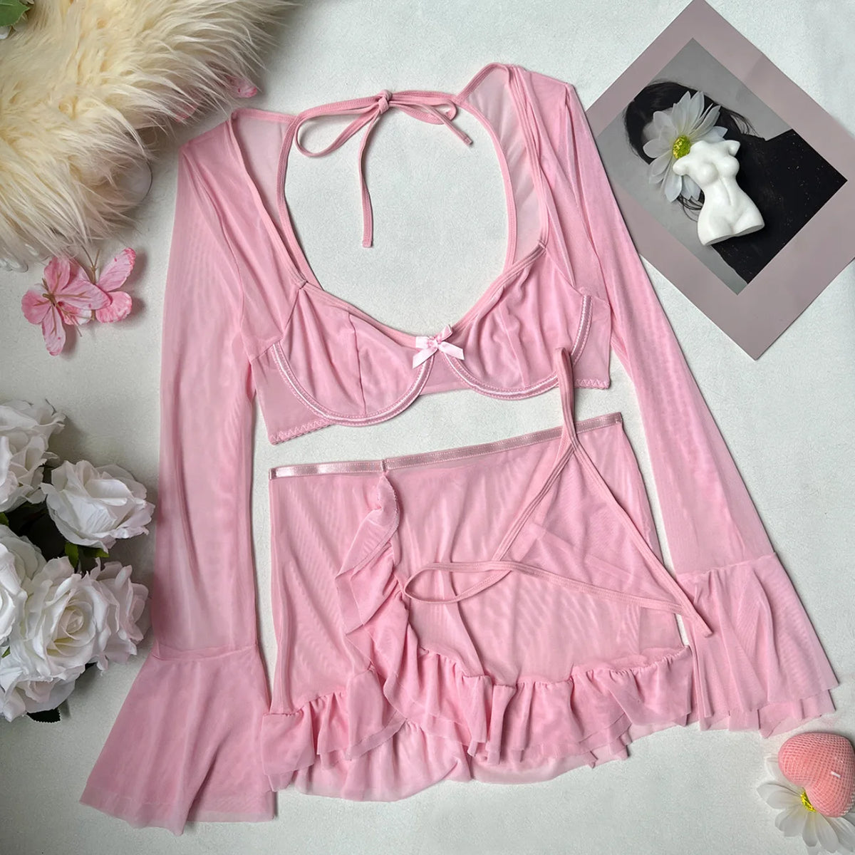 Pink lingerie set with floral decorations on a light background