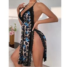 Woman wearing a leopard print dress with blue butterfly details in an indoor setting.