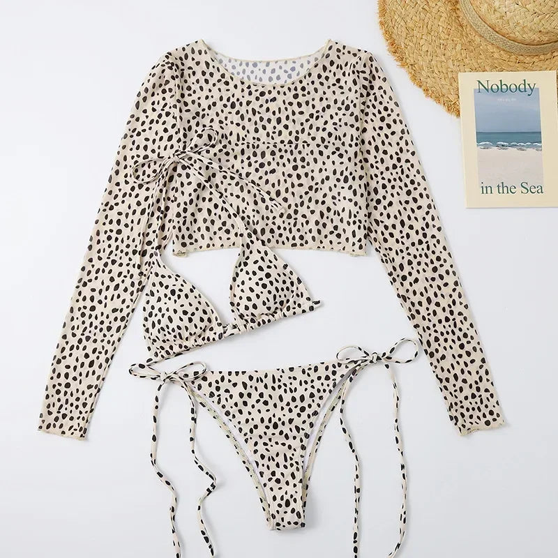 Leopard print bikini set with a straw hat and book on a white background