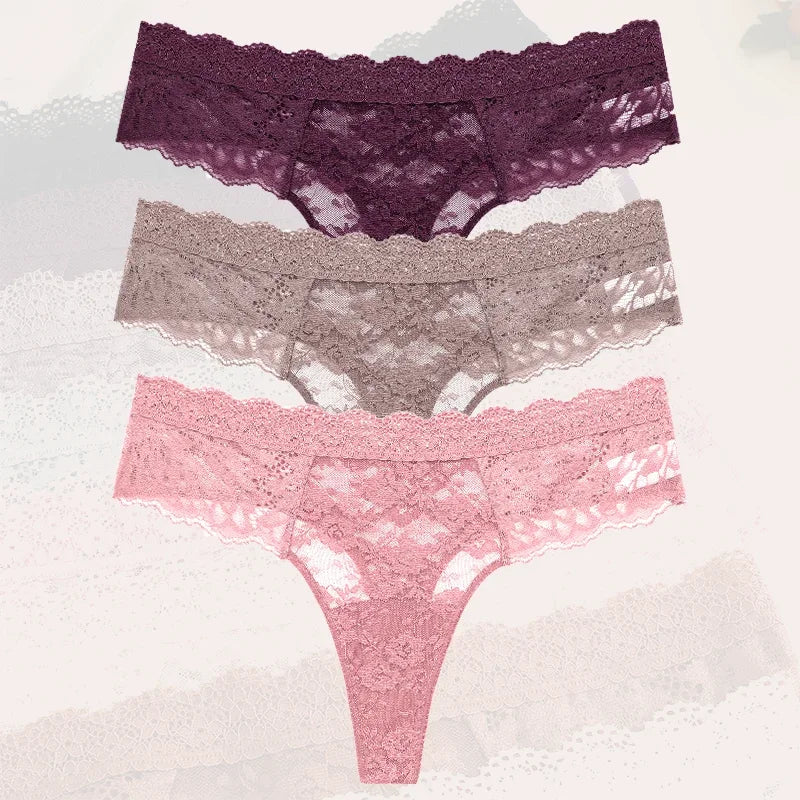 Three pairs of lace underwear in purple, gray, and pink on a textured white background.