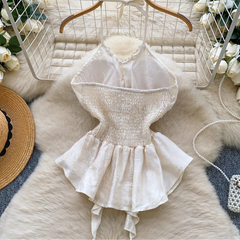 White lace dress on a wooden hanger with decorative elements on a textured surface