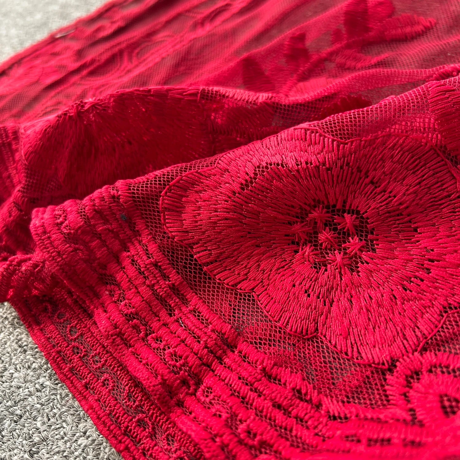 Close-up of red lace fabric with intricate patterns