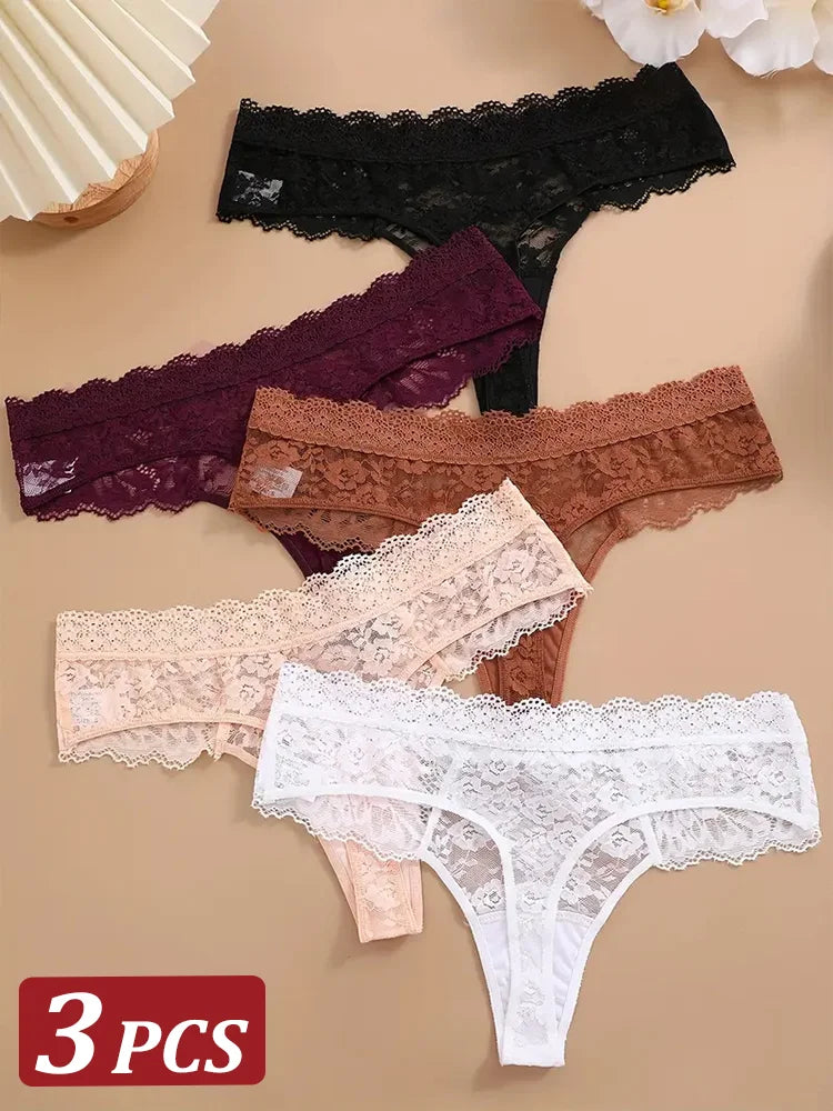 Set of three lace underwear pieces in black, brown, and white on a beige background.
