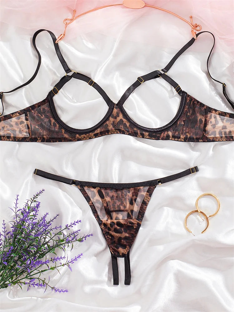 Leopard print lingerie set on a white fabric background with flowers and rings.
