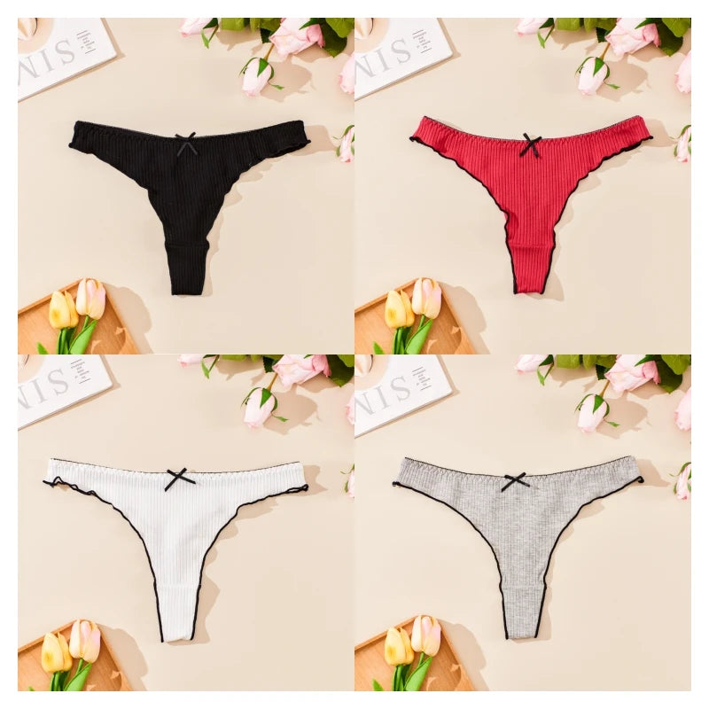 Four pairs of black, red, white, and gray thongs on a beige surface with floral decorations.