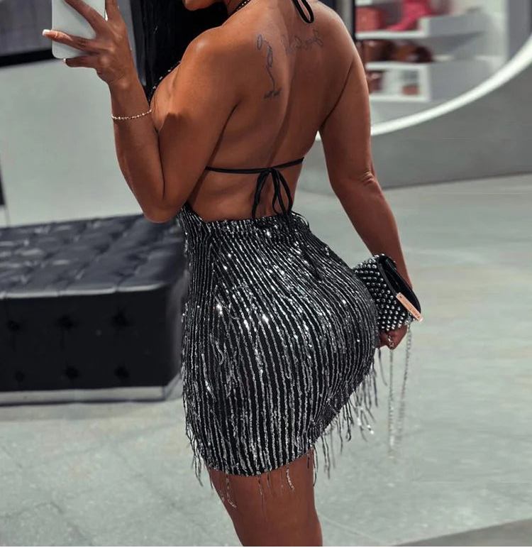 Woman taking a mirror selfie wearing a black beaded outfit.