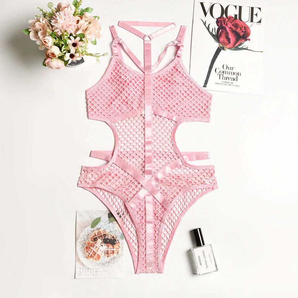 Pink lace swimsuit with flowers, magazine, and perfume bottle on a white surface
