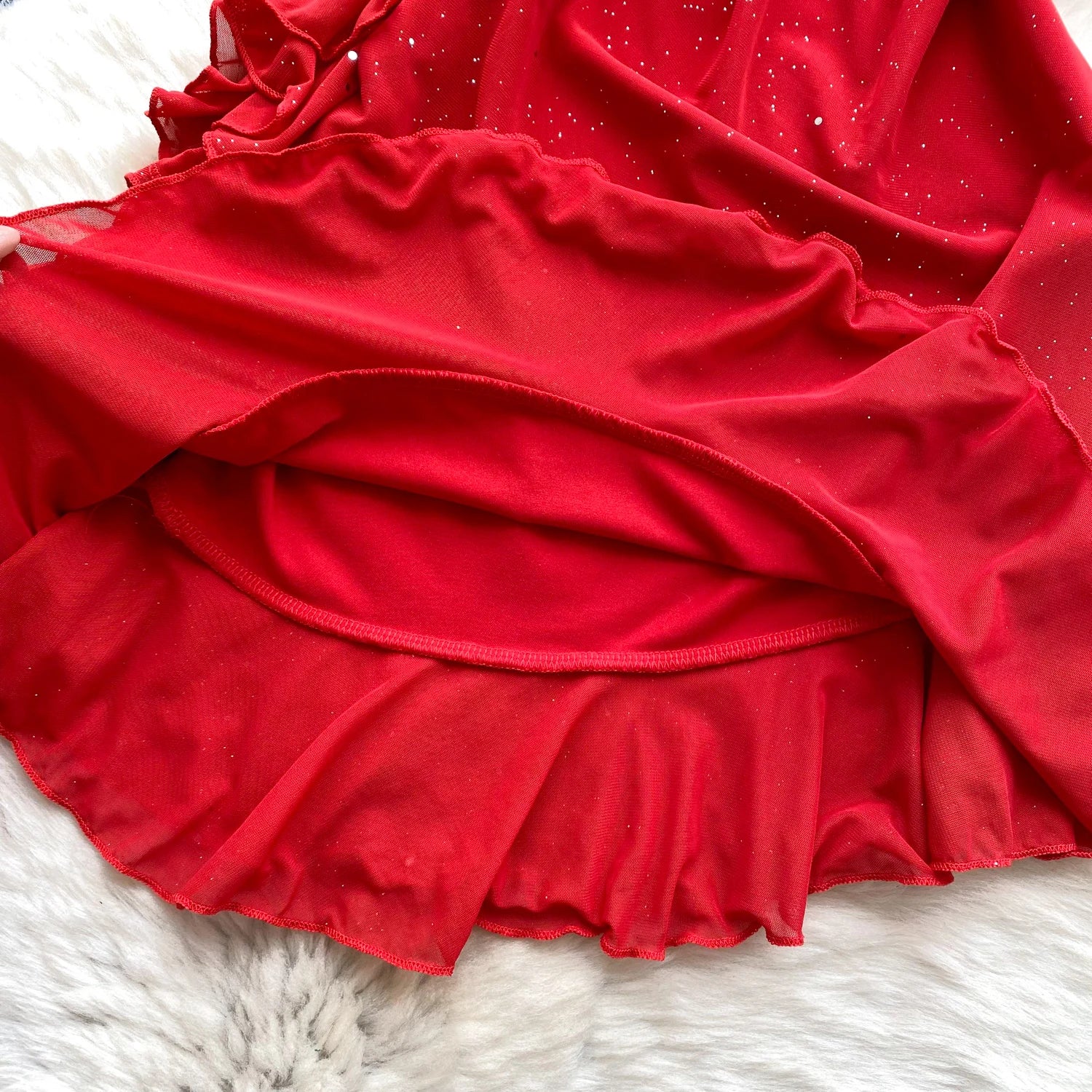 Red dress with a ruffled skirt on a white fur surface