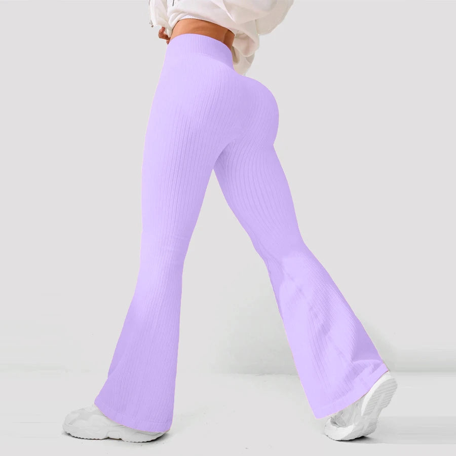 Person wearing light purple flared pants on a plain background