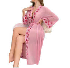 Pink robe with red floral patterns worn by a model on a white background
