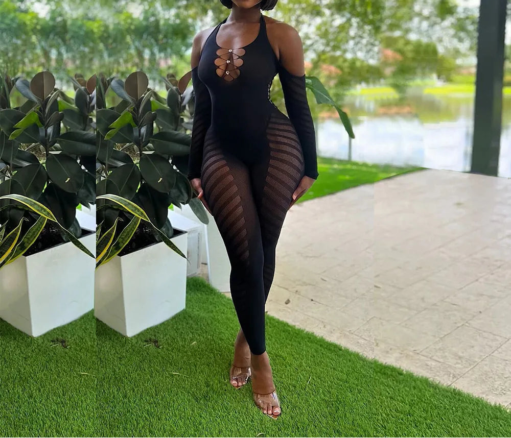 Woman in a black outfit standing outdoors with greenery and a lake in the background