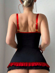 Person wearing a black and red dress with thin straps on a plain background