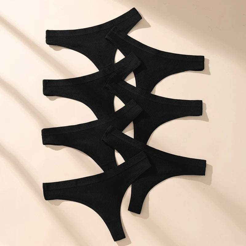 Black thong panties on a beige background