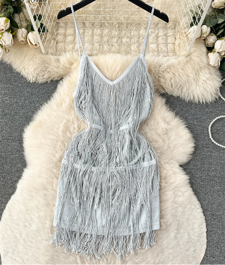 Gray fringe dress on a hanger with decorative background