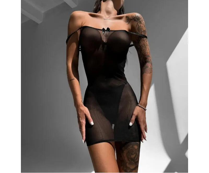 Woman wearing a black lace lingerie set against a neutral background