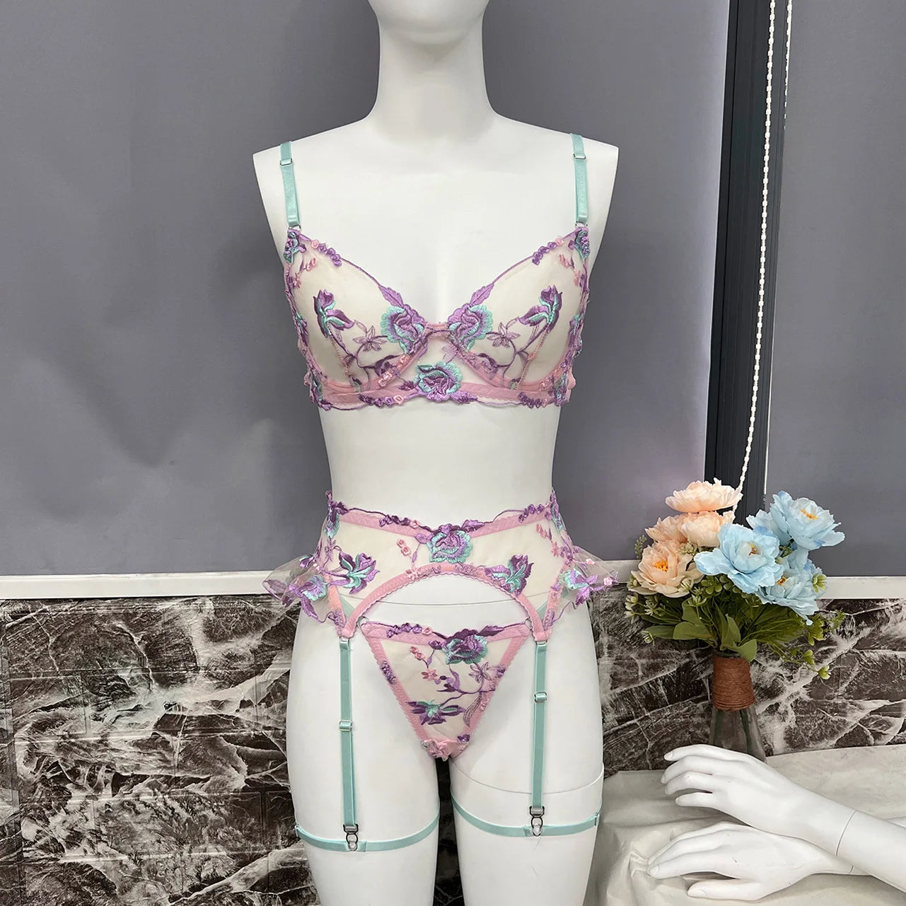 Floral lingerie set on a mannequin with a gray background