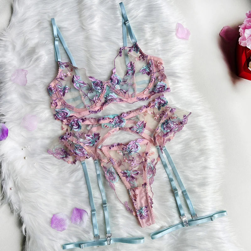 Floral lingerie set on a fluffy white surface with pink flowers.