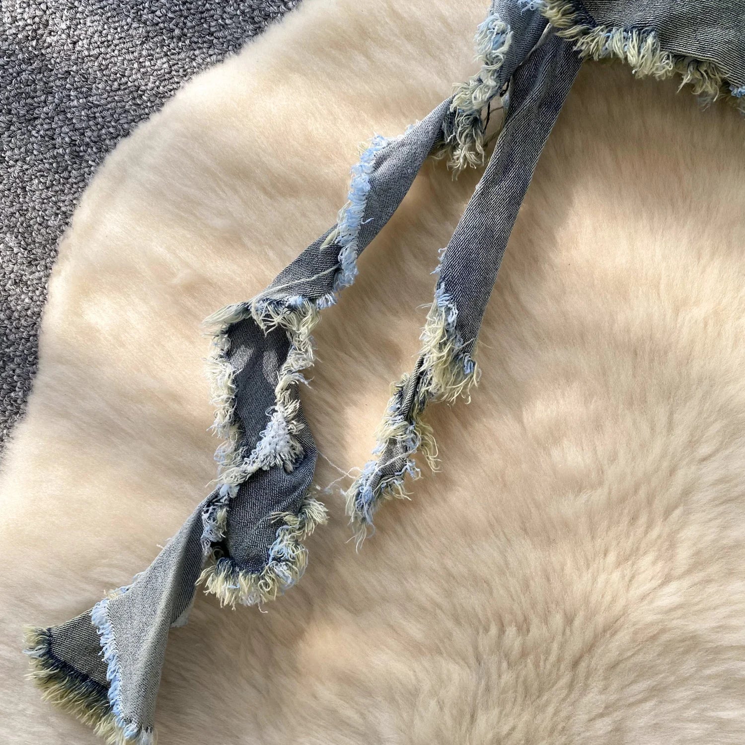 Gray dog rope toy on a fluffy beige surface