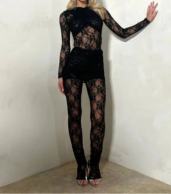Woman wearing a black lace outfit against a plain background