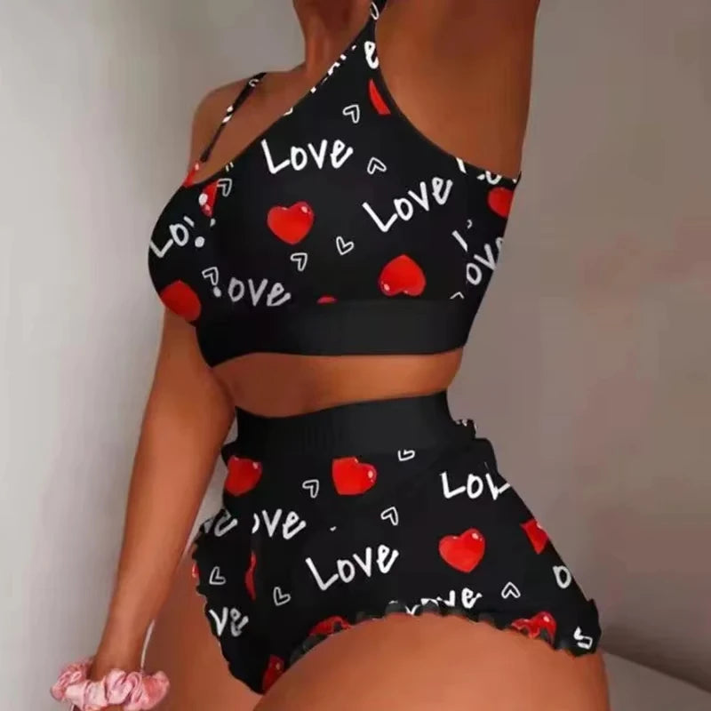 Black crop top and shorts set with 'LOVE' and heart patterns on a plain background