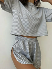 Person wearing a black and white striped outfit with a crop top and shorts on a plain background