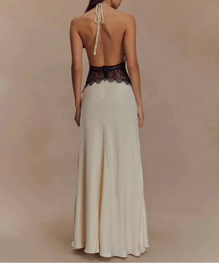 Woman wearing a long, elegant dress with a lace bodice on a beige background