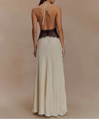 Woman wearing a long, elegant dress with a lace bodice on a beige background