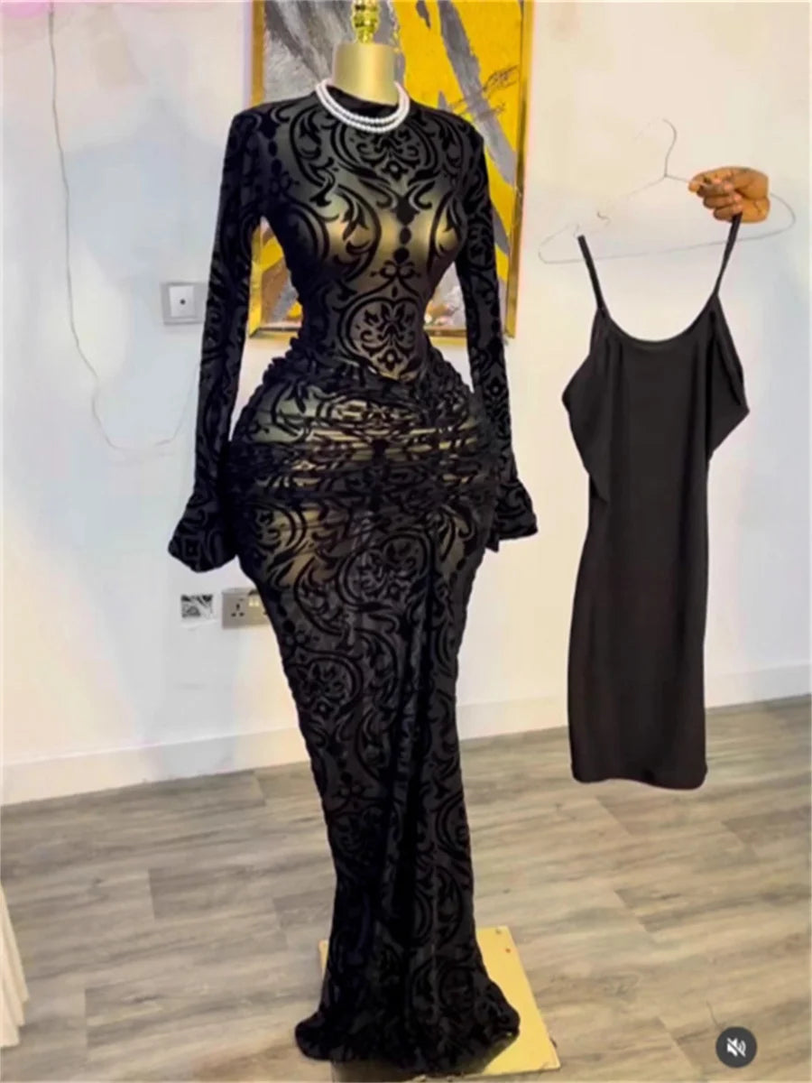 Black lace dress on a mannequin with a plain background