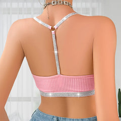 Pink crop top with silver straps on a neutral background