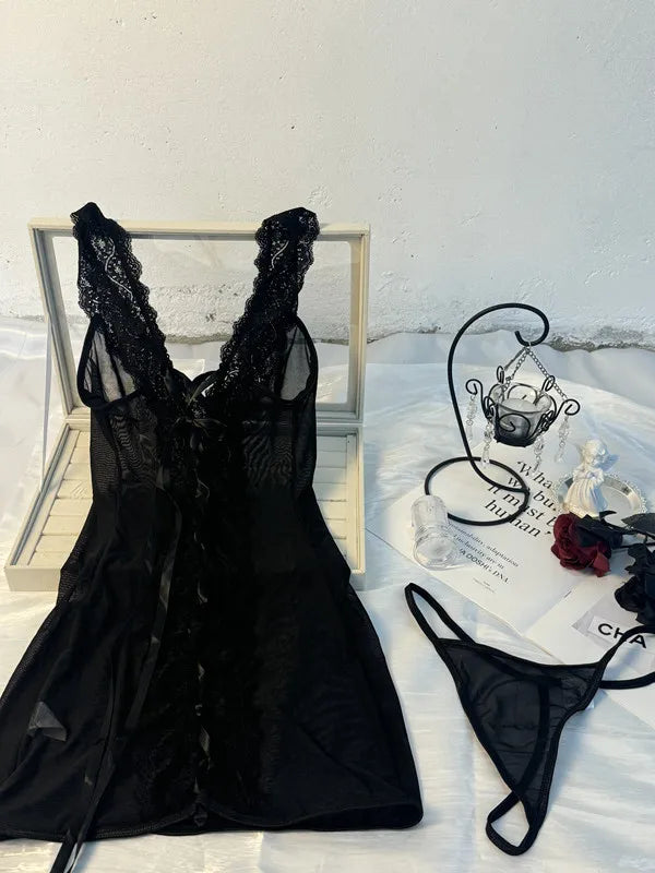 Black lace dress and thong on a light surface with a mirror in the background