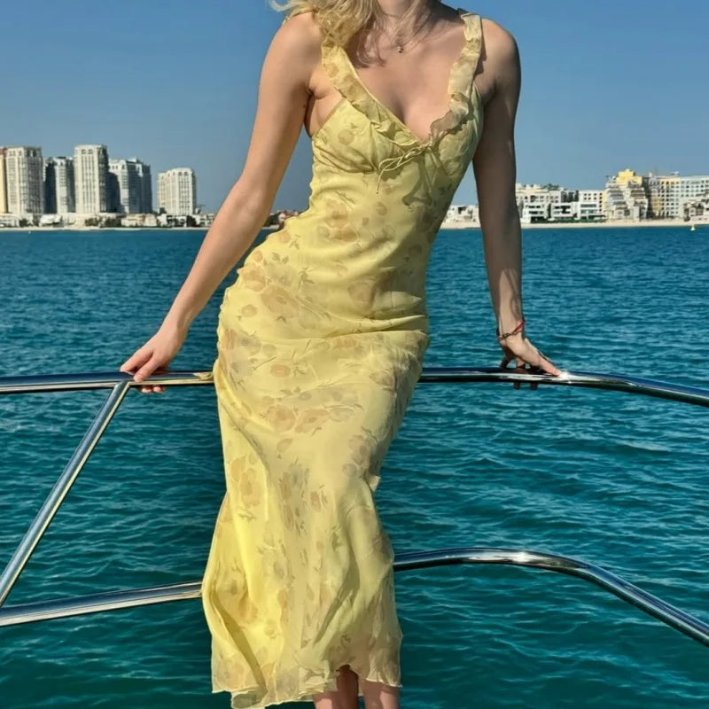Woman in a yellow dress standing on a boat with a city skyline in the background