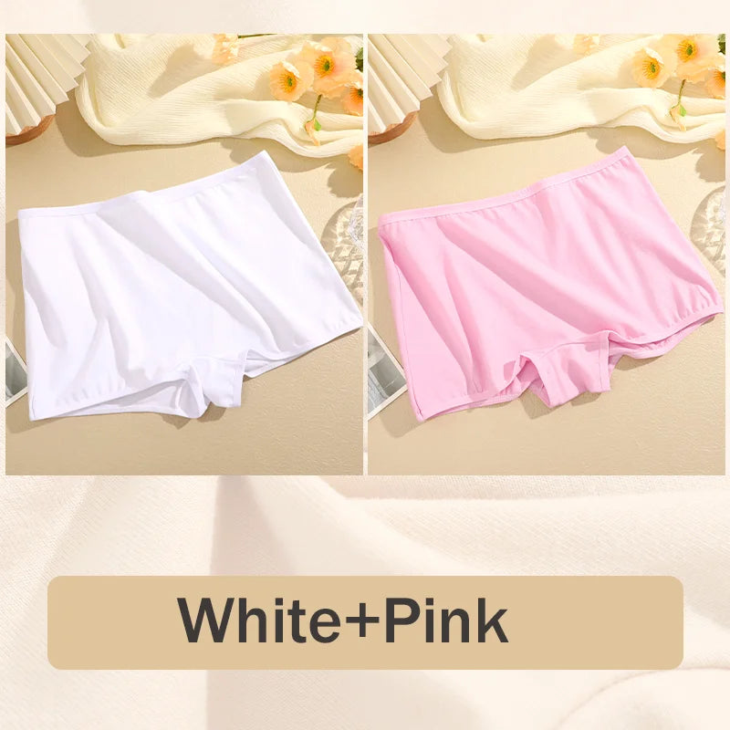 Two pairs of underwear, one white and one pink, on a beige surface with flowers in the background.
