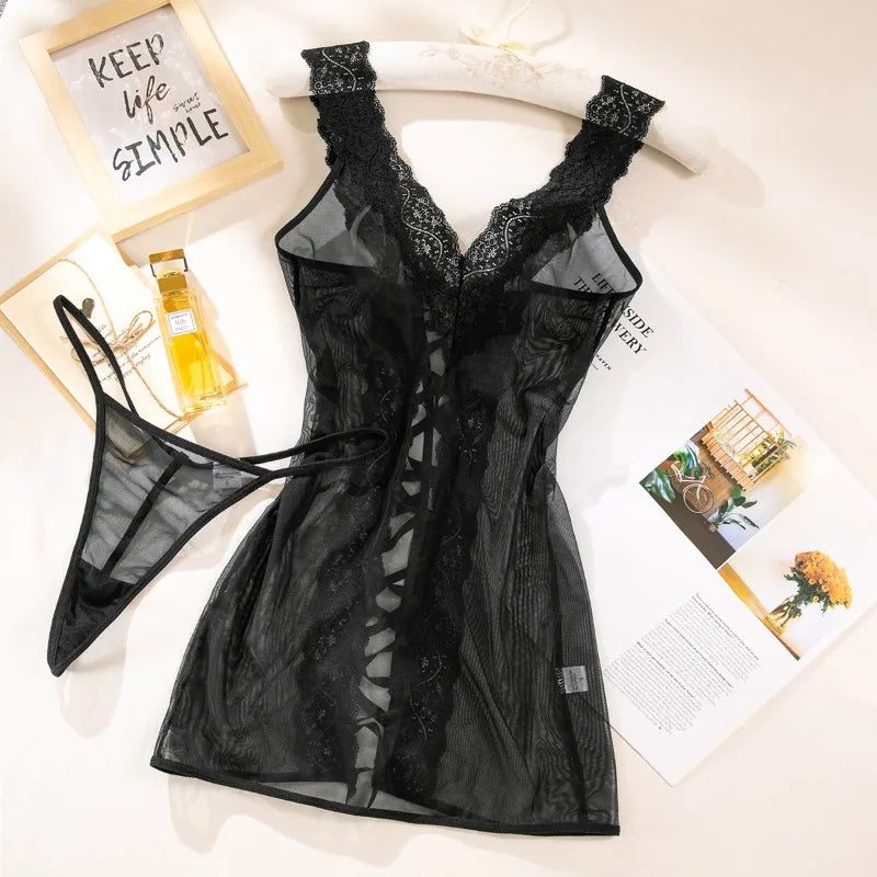 Black lace lingerie set on a white surface with magazines and a bottle of perfume.