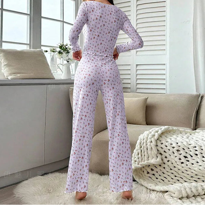 Woman wearing a floral pajama set in a cozy living room.