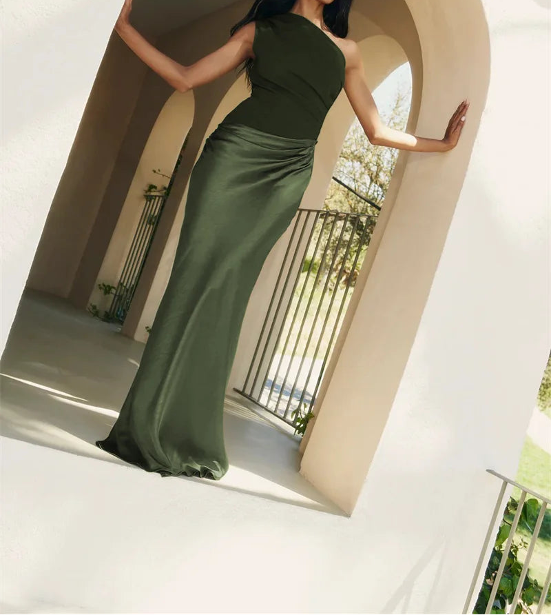 Woman in a green dress standing in an architectural archway with a blurred outdoor background