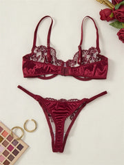 Burgundy lace lingerie set on a light background with makeup products and flowers.