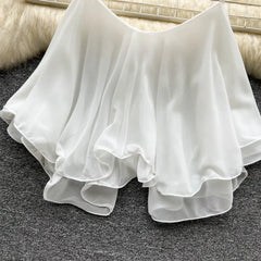 White chiffon skirt on a textured surface with a neutral background