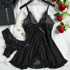 Black lace lingerie set on a white surface with red roses and jewelry.