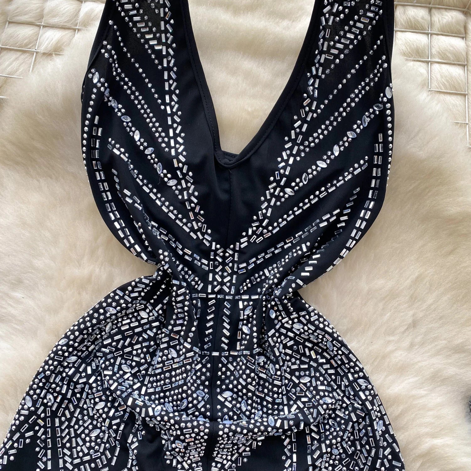 Black and white patterned dress on a textured beige surface