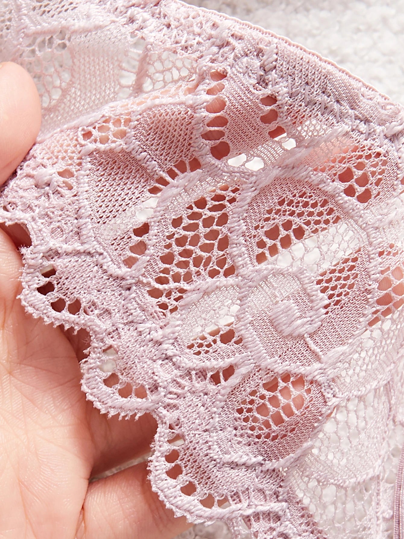 Close-up of pink lace fabric held in a hand