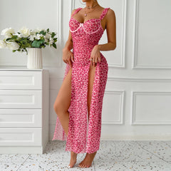 Woman wearing a pink leopard print dress in a room with white walls and a vase of flowers.