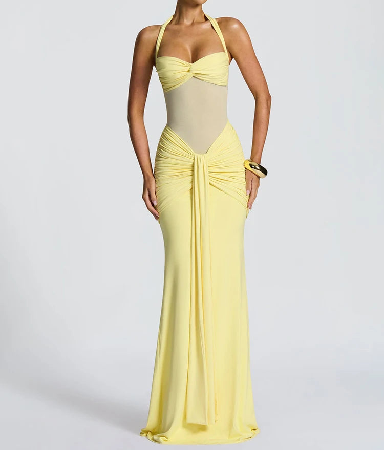 Woman wearing a yellow and beige evening gown on a plain background