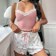 Woman wearing a pink lace top and floral shorts in a room.