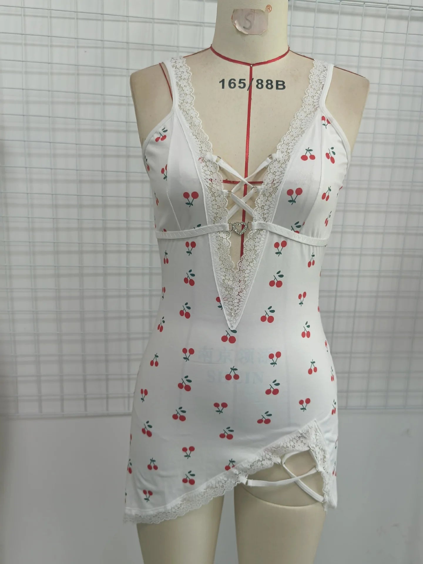 White lace-trimmed nightgown with cherry pattern on a mannequin against a grid background