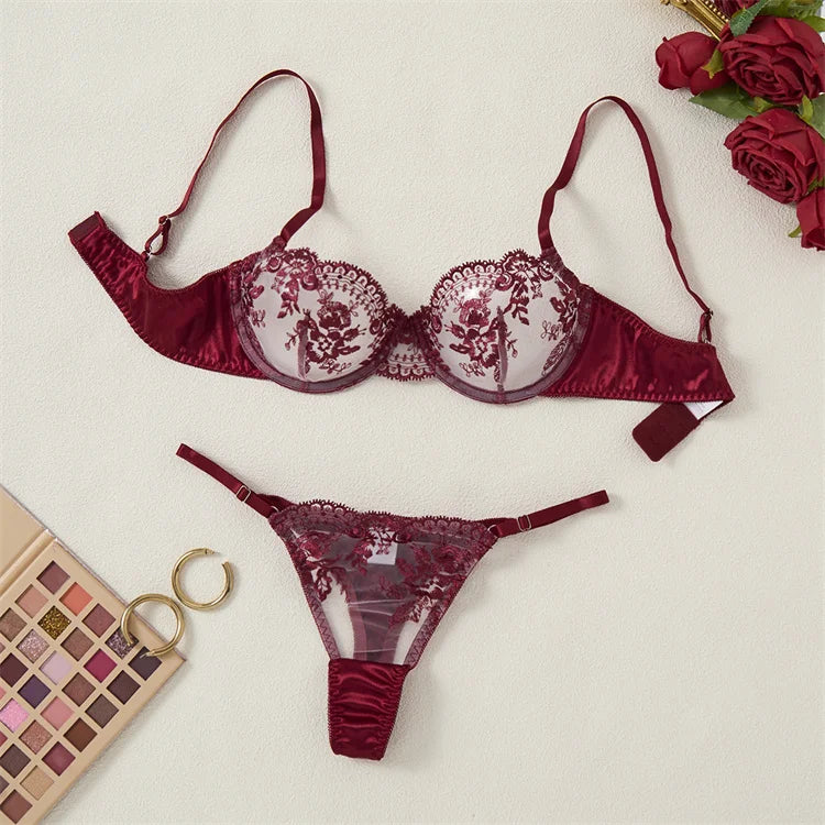 Red lace lingerie set with roses and makeup palette on a light background
