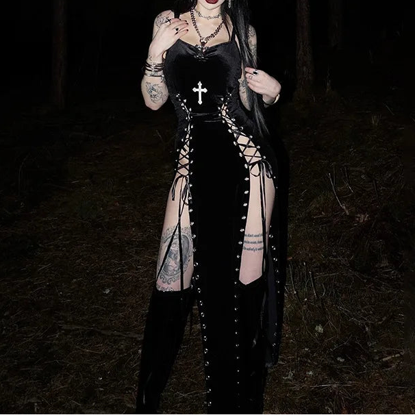 Person wearing a black outfit with lace-up design in a dark forest setting