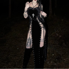 Person wearing a black outfit with lace-up design in a dark forest setting